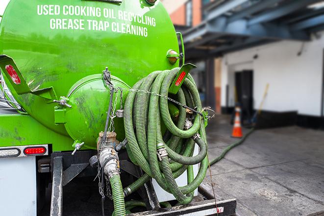 worker pumping grease trap at commercial kitchen in Amite City, LA